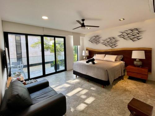 a bedroom with a bed and a couch at Exclusivo 3 Hab, Terraza Privada, Alberca y Asador in Tulum