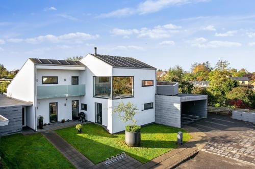 a white house with a lot of windows at Anneks med eget toilet og bad - gratis parkering in Horsens