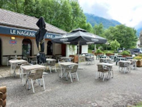 a group of tables and umbrellas in front of a building at Studio La LAUZE in Ax-les-Thermes