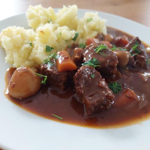 a plate of food with meat and mashed potatoes and gravy at Penzion Pod Skalou in Bechyně