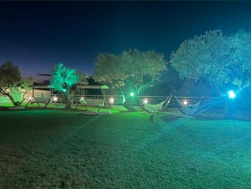 a park at night with green lights and hammocks at Aroma studios&apartments 2 in Vourvourou