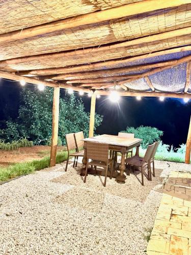 a wooden table and chairs under a wooden pergola at Le Tre Aie in San Giovanni a Piro