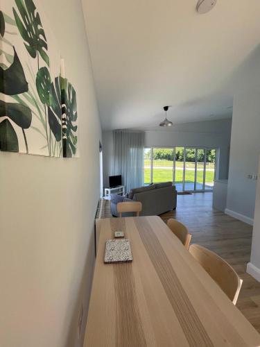 a dining room with a wooden table and a living room at Kildare Holiday Apartments No 3 in Kildare