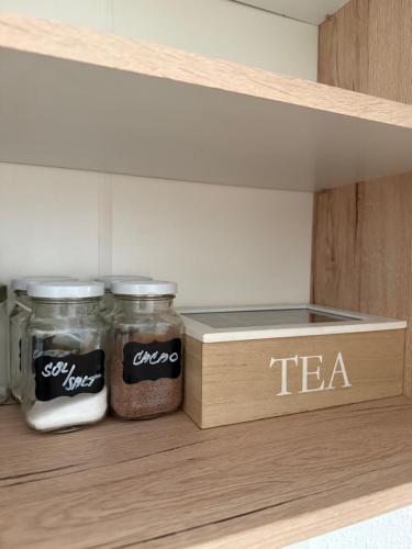 two jars of spices and a wooden box in a pantry at Kovarik Apartments I in Olomouc