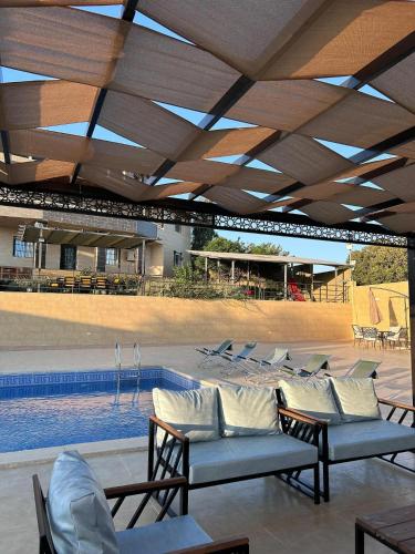 a pool with lounge chairs and a swimming pool at Mountain farm in Ajloun