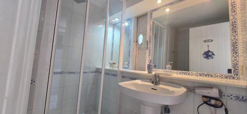 Un baño blanco con lavabo y espejo. en Casa Playa San Agustin, en San Agustín