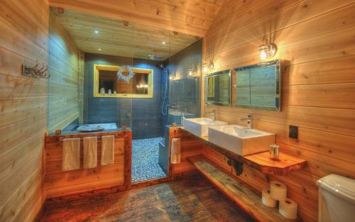 a wooden bathroom with two sinks and a mirror at Les Bouleaux - Les Chalets Spa Canada in La Malbaie
