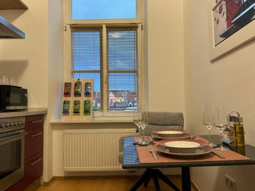 a kitchen with a table with plates and wine glasses at Isartor Rooms - SHARED BATHROOM in Munich