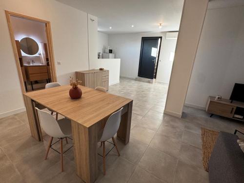 a dining room with a wooden table and chairs at Entre Campagne et Ville in Marcorignan