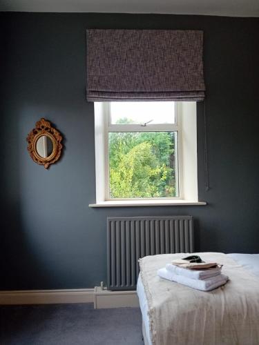a bedroom with a window and a bed with towels on it at The Almanage in Clogheen