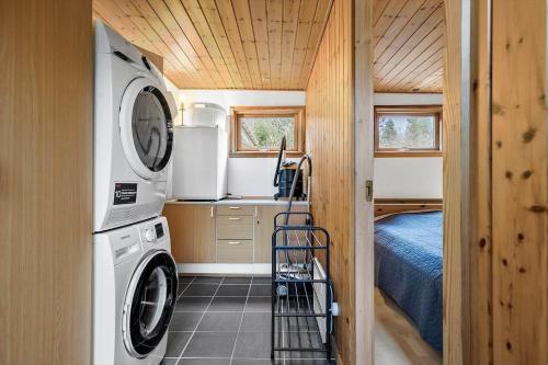a small kitchen with a washing machine and a bed at 4759-Ronne-Stampen-Vej-1-Hus-4 in Rønne