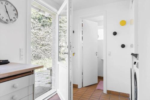a kitchen with white walls and a clock on the wall at 4728-Ronne-Brobakken-16 in Rønne