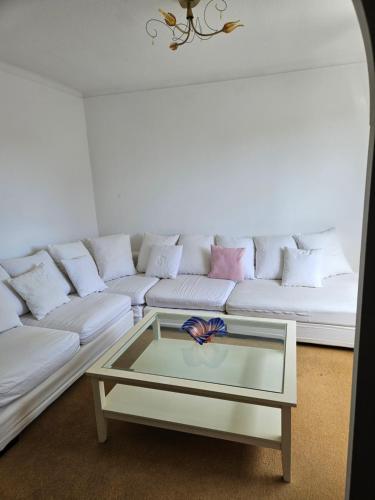a living room with a white couch with a glass coffee table at Maison ouvrière pour 8 personnes in Trignac