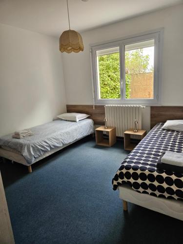 a bedroom with two beds and a window at Maison ouvrière pour 8 personnes in Trignac