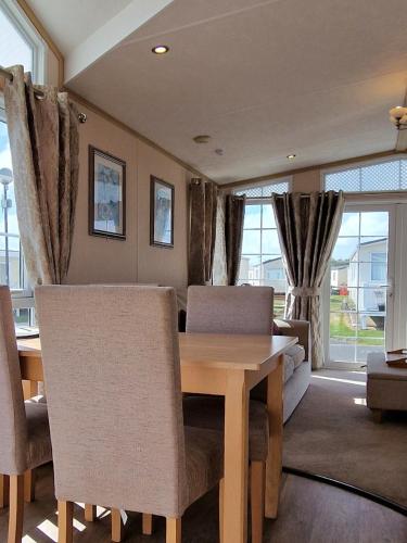a living room with a wooden table and chairs at Hampton's Retreat, Haven Church Farm in Pagham