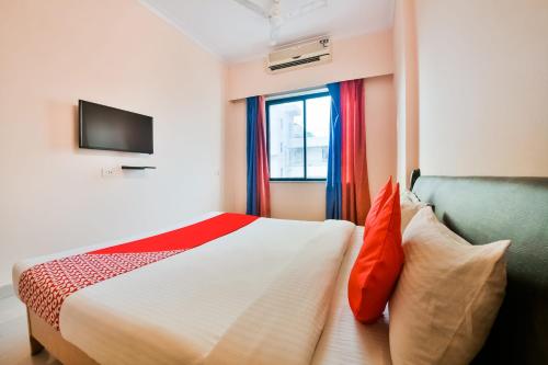 a bedroom with a bed and a window at Hotel O Soft Petals in Kota