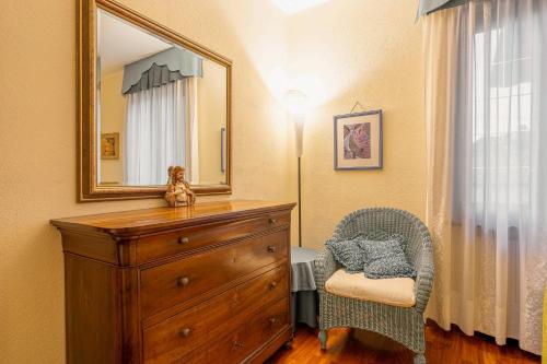 a bedroom with a dresser and a mirror and a chair at Cascina Albarella in Canelli