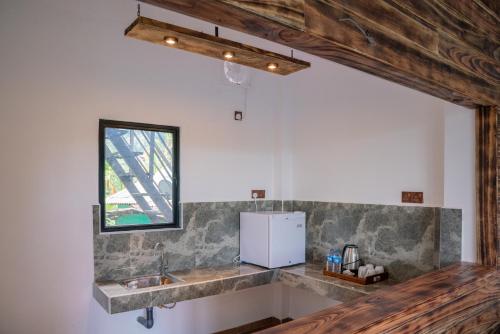 una cocina con fregadero y frigorífico en Flourish Inn Ella, en Ella