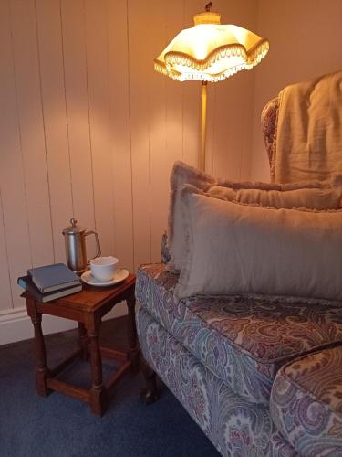 a living room with a table with a lamp and a couch at The Almanage in Clogheen