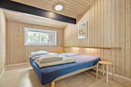 ein Schlafzimmer mit einem Bett in einer Holzwand in der Unterkunft 1474 Aakirkeby - Boesparken 20 in Vester Sømarken