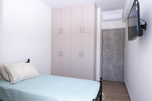 a small bedroom with white cabinets and a bed at Smiles Apartments With Panoramic View in Zipárion