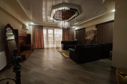 a living room with a couch and a chandelier at Hotel Harmony Premium in Kutaisi