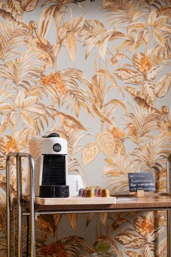 a microwave on a table with a wallpaper at B&B Maas en Heuvel Maastricht in Maastricht