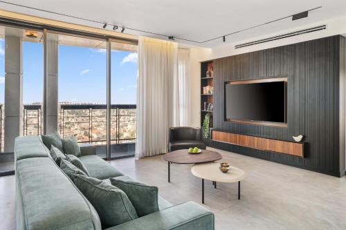 a living room with a couch and a tv at JTower - Presidential 3BR Parking with amazing view city center in Jerusalem
