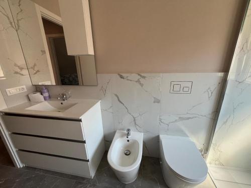 Un baño blanco con inodoro y lavabo. en Appartamento Fabbricotti, en Livorno