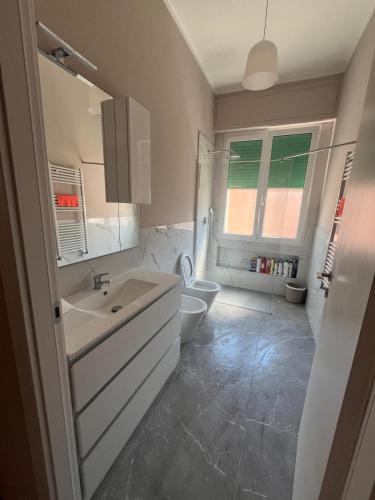 a white bathroom with a sink and a toilet at Appartamento Fabbricotti in Livorno
