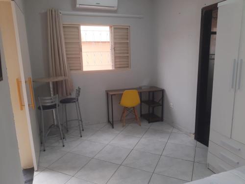 a room with a table and chairs and a yellow chair at Casa Studio 1 Quarto in São José dos Campos