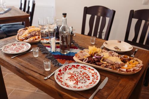 Una mesa de madera con platos de comida encima. en Popasul Zorilor, en Şişeşti