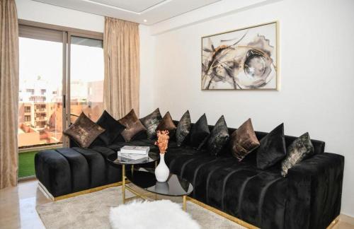 a black couch with pillows in a living room at Appart luxe arya in Fès