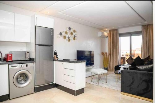 a kitchen with a washer and a living room at Appart luxe arya in Fès