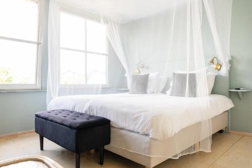 a bedroom with a white bed with a canopy at B&B Maas en Heuvel Maastricht in Maastricht