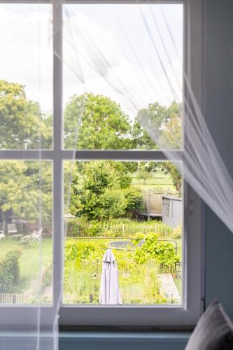 an open window with a view of a garden at B&B Maas en Heuvel Maastricht in Maastricht