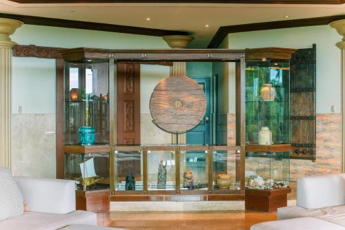 a glass display case in a living room with vases at Sunrise House - a Tranquil Tropical Retreat in Loboc