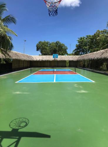a tennis court with a net and a basketball hoop at Sunrise House - a Tranquil Tropical Retreat in Loboc