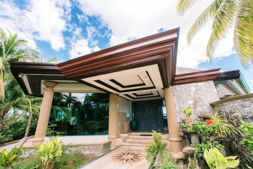 a house with a wooden roof at Sunrise House - a Tranquil Tropical Retreat in Loboc