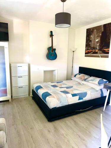 a bedroom with a bed and a guitar on the wall at Studio flat in central London in London