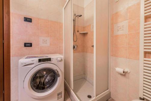 a washing machine in a bathroom with a shower at Trento33 in Lazise