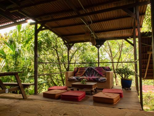a covered deck with a chair and ottoman at REFUGIO LA ROCA in Los Santos