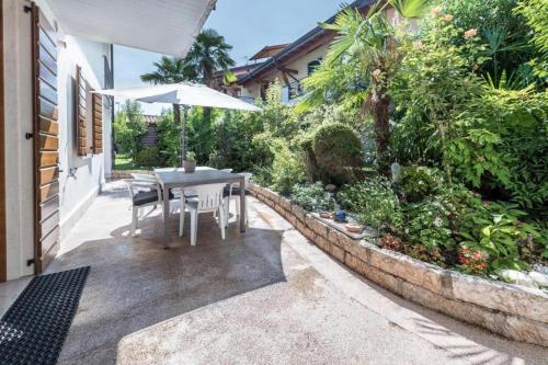 a table and chairs with an umbrella on a patio at Trento33 in Lazise