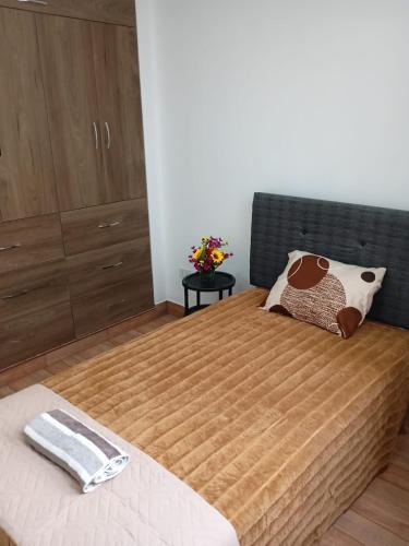 a bedroom with a large bed with a wooden headboard at Apart Hotel Bottger in Tacna