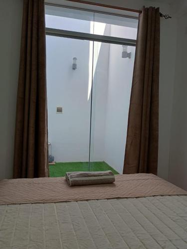 a bedroom with a bed and a large window at Apart Hotel Bottger in Tacna