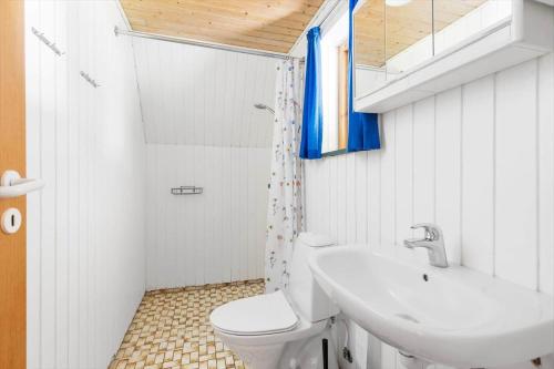 a white bathroom with a toilet and a sink at 3647-Nexo-Frederiksvej-8-A in Neksø