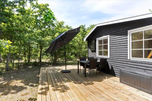 a patio with a table and an umbrella at 4754-Ronne-Stampen-Vej-8-Hus-5 in Rønne