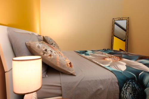 a bedroom with a bed with pillows and a lamp at Case vacanza e camere in Villa Isabella con parcheggio custodito e wifi in Gioia del Colle
