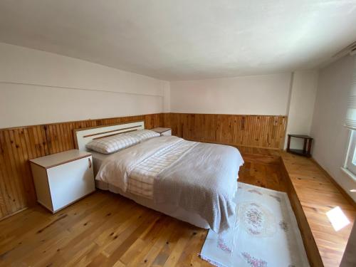 a bedroom with a bed and a wooden floor at Özçelik Apart in Çaykara
