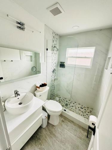 a bathroom with a sink and a toilet and a shower at Cozy Retreat Near Downtown Fort Myers in Fort Myers